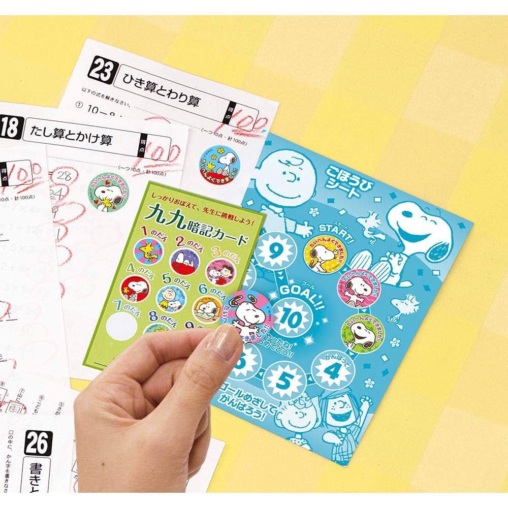 Close-up of hand holding a Snoopy Motivation Sticker from a colorful Japanese study reward card set