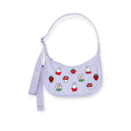 The Miffy x Baggu Small Nylon Crescent by Baggu is a light purple, small nylon bag with a strap, featuring cartoon bunnies, strawberries, flowers, mushrooms, Miffy embroidery, and "BAGGU" embossed on the strap—a cute collaboration piece.