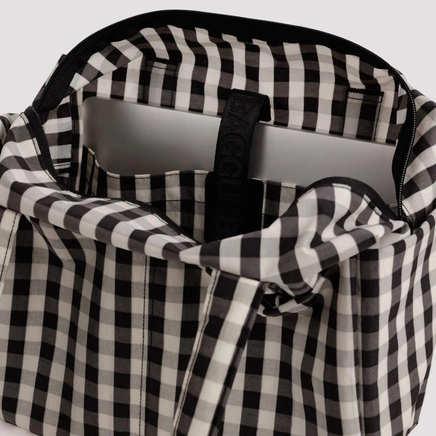 Gingham tote interior with black plastic zipper pull and pocket divider
