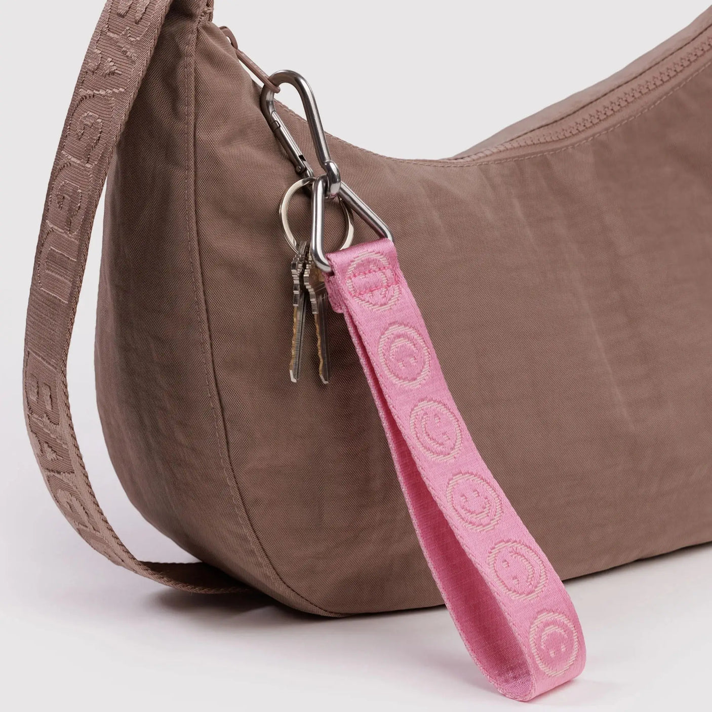 Pink logo keychain strap with metal keyring and hook, patterned fabric loop