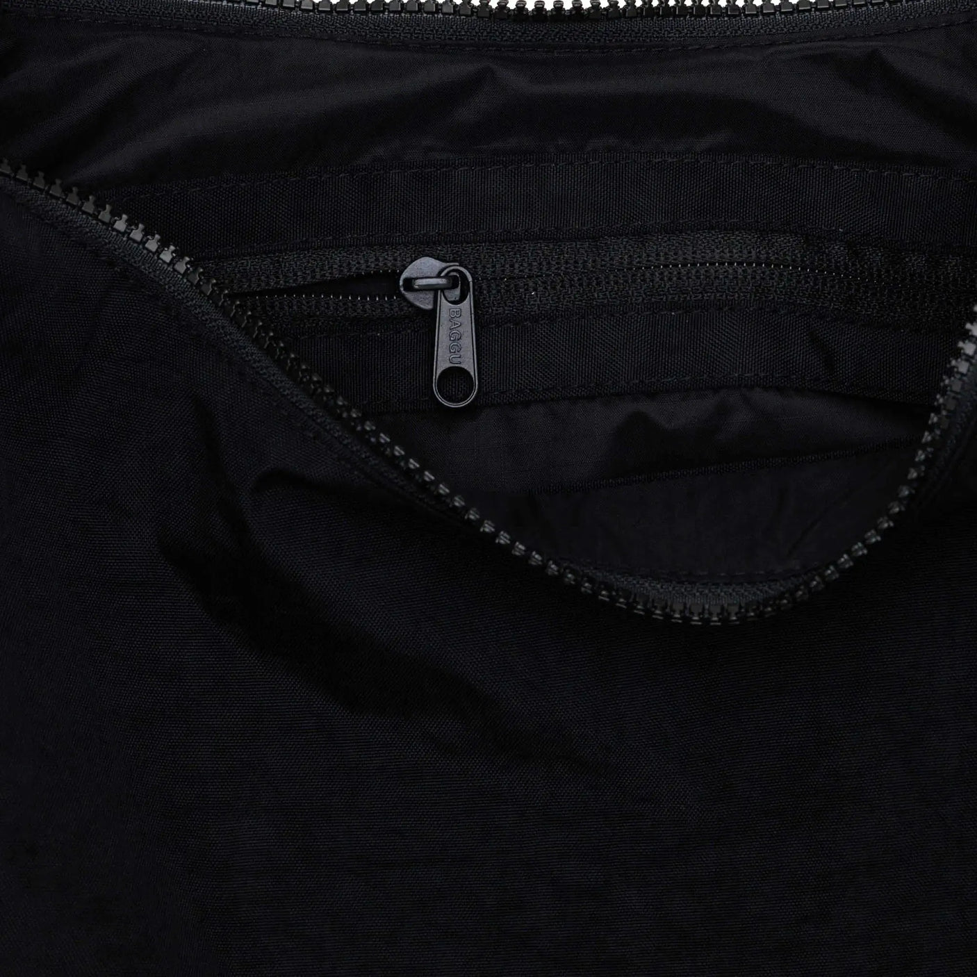 Black crescent bag interior with zippered pocket and metal zipper pull