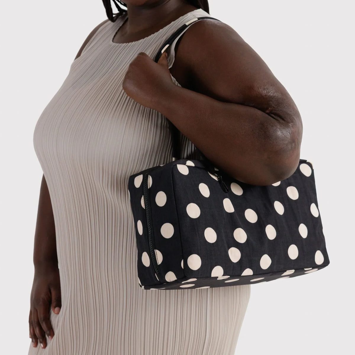 Medium nylon bowler bag with cream polka dots, held by top handles