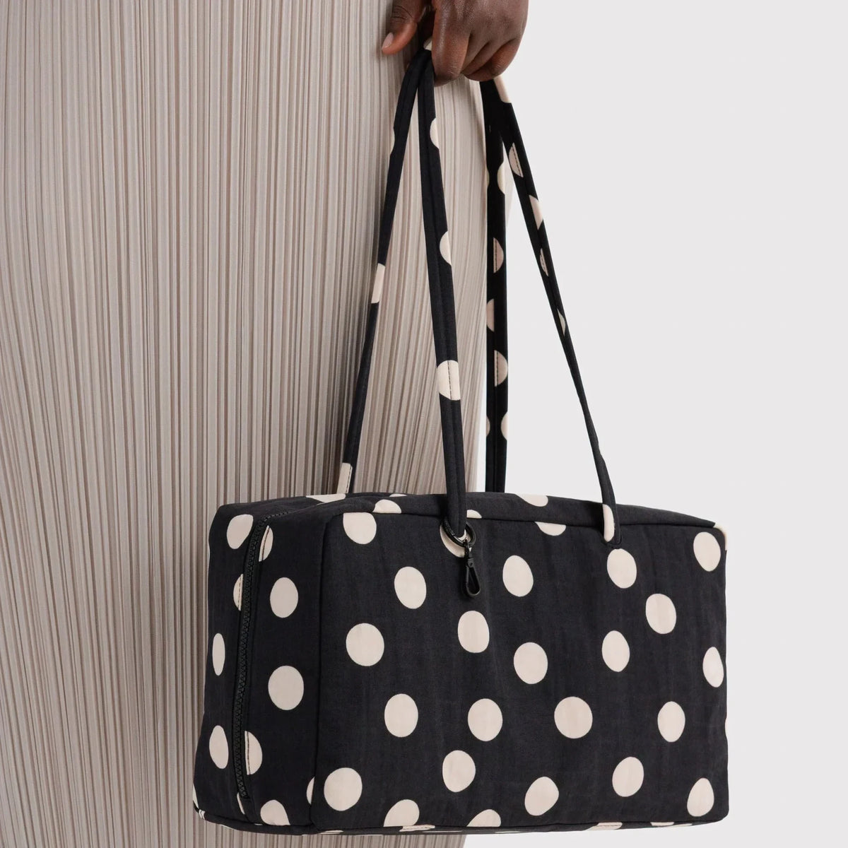 Medium nylon bowler bag with black and cream polka dots, side view with handles