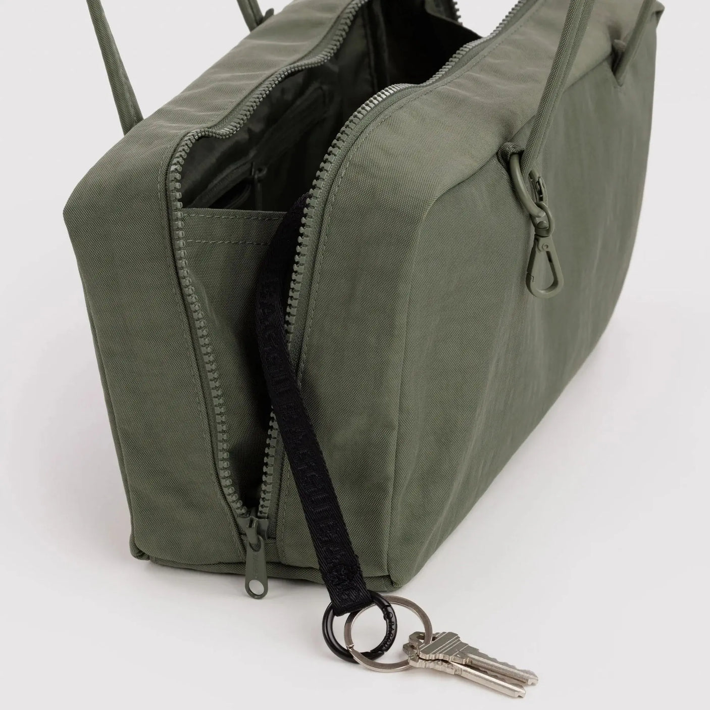 Olive green nylon bowler bag interior, zip pocket and zipper pull with key ring
