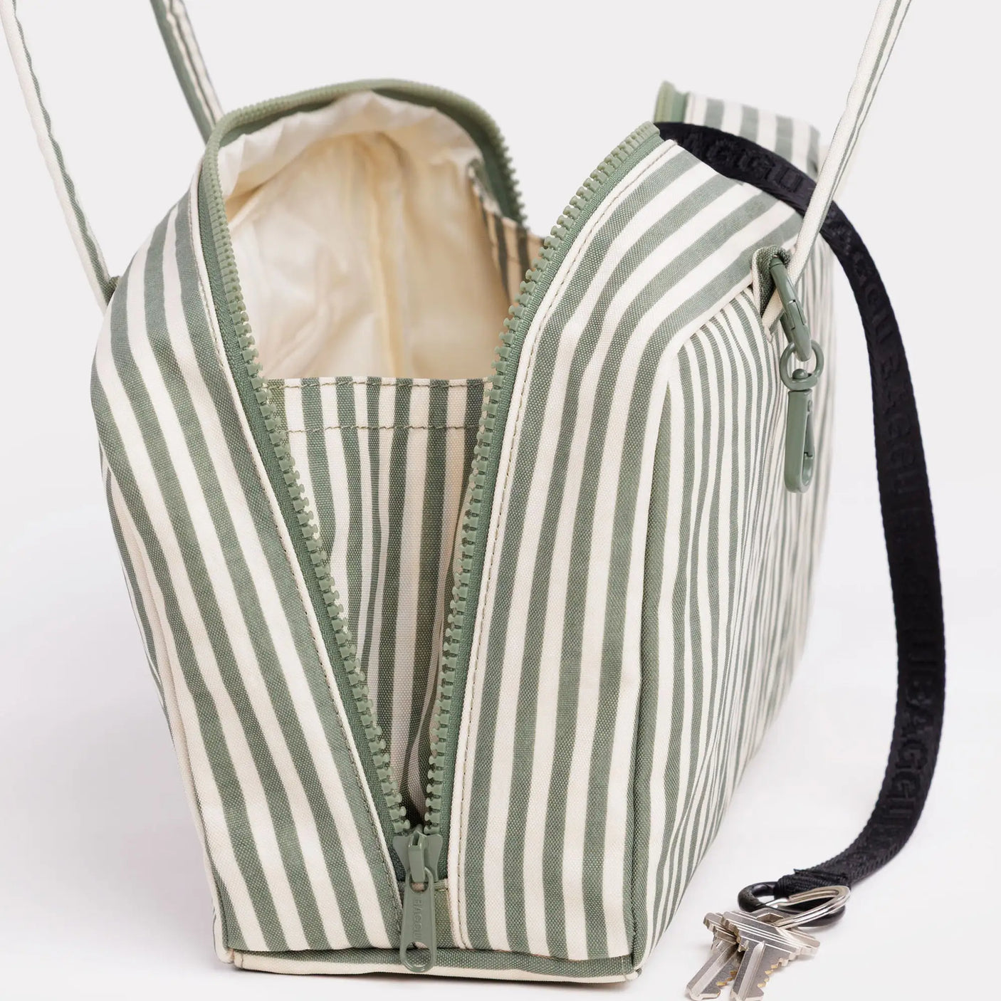 Sage-striped nylon bowler bag with zip top and green trim, side strap and metal hardware