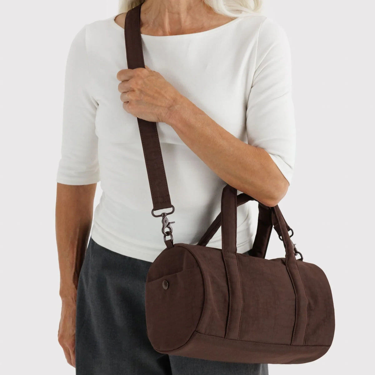 Coffee-brown nylon duffle bag with top handles and adjustable shoulder strap