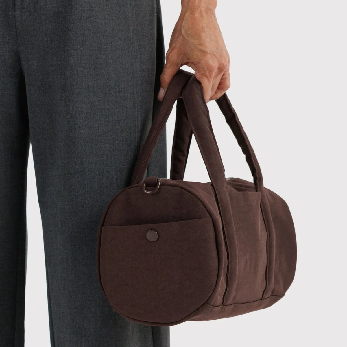 Coffee-brown duffle bag with round front pocket and top handle carry