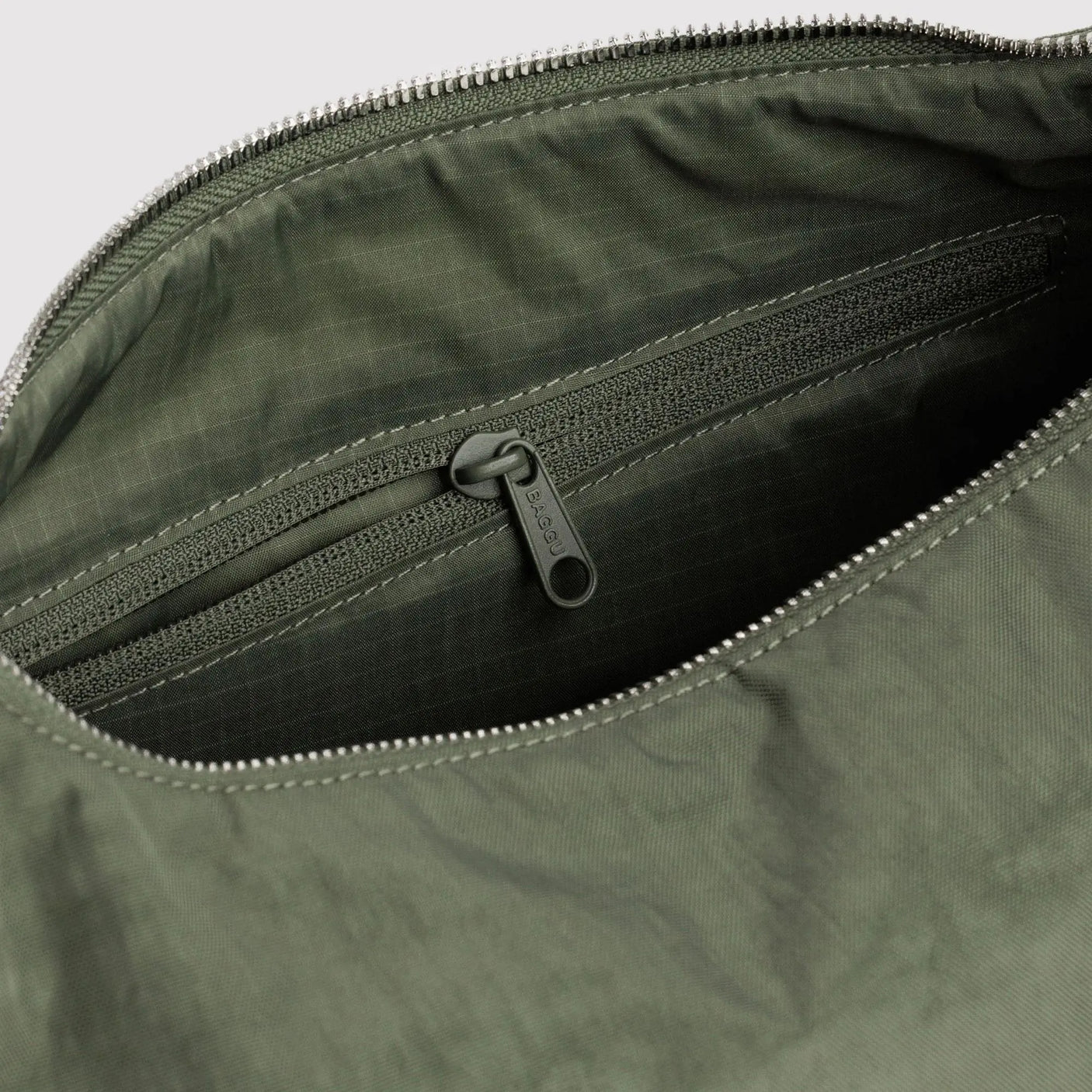 Olive green nylon bag interior with zip-top closure and gray lining