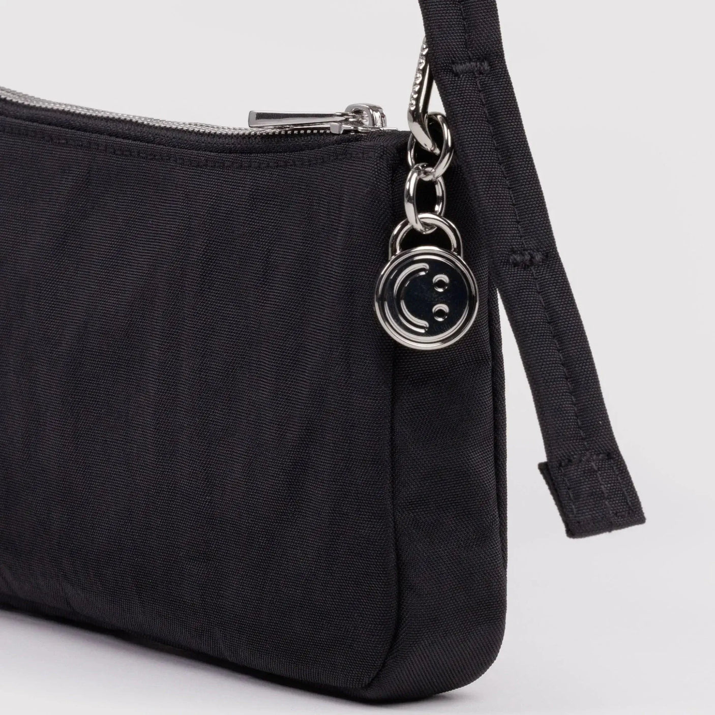 Black nylon pochette side with zip, metal rings, and strap attachment tab
