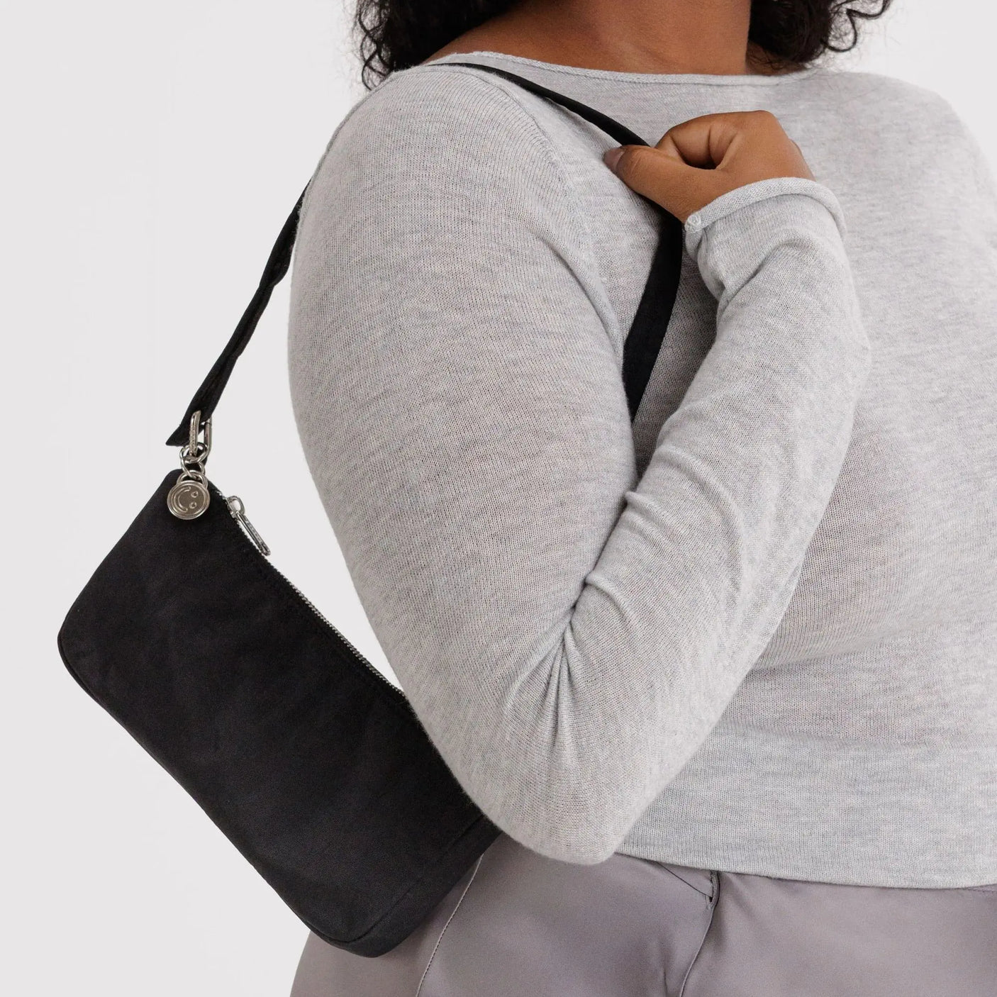 Baggu nylon pochette black worn crossbody with adjustable strap and zip closure