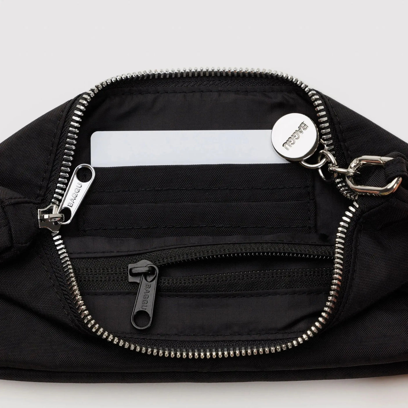 Baggu nylon pochette black interior with zip pocket and striped zipper track, silver pull