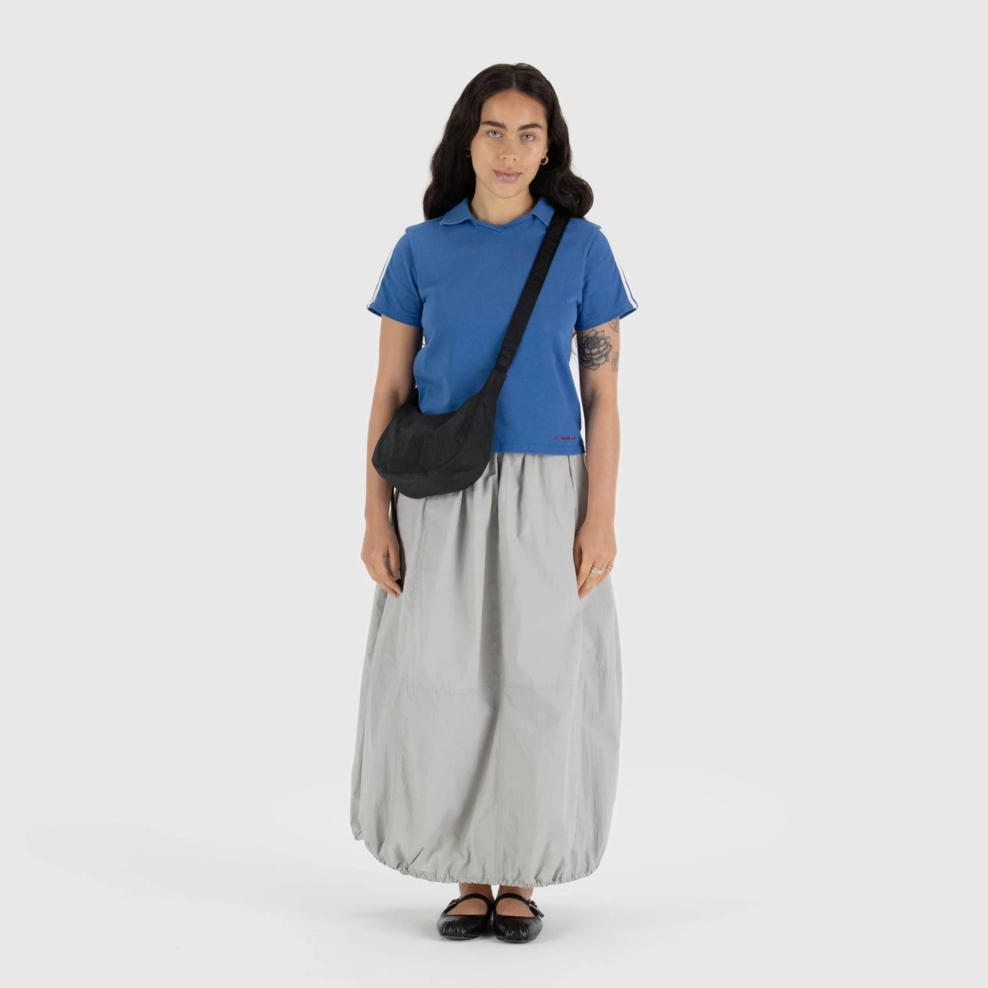 Black crescent shoulder bag worn crossbody with adjustable strap