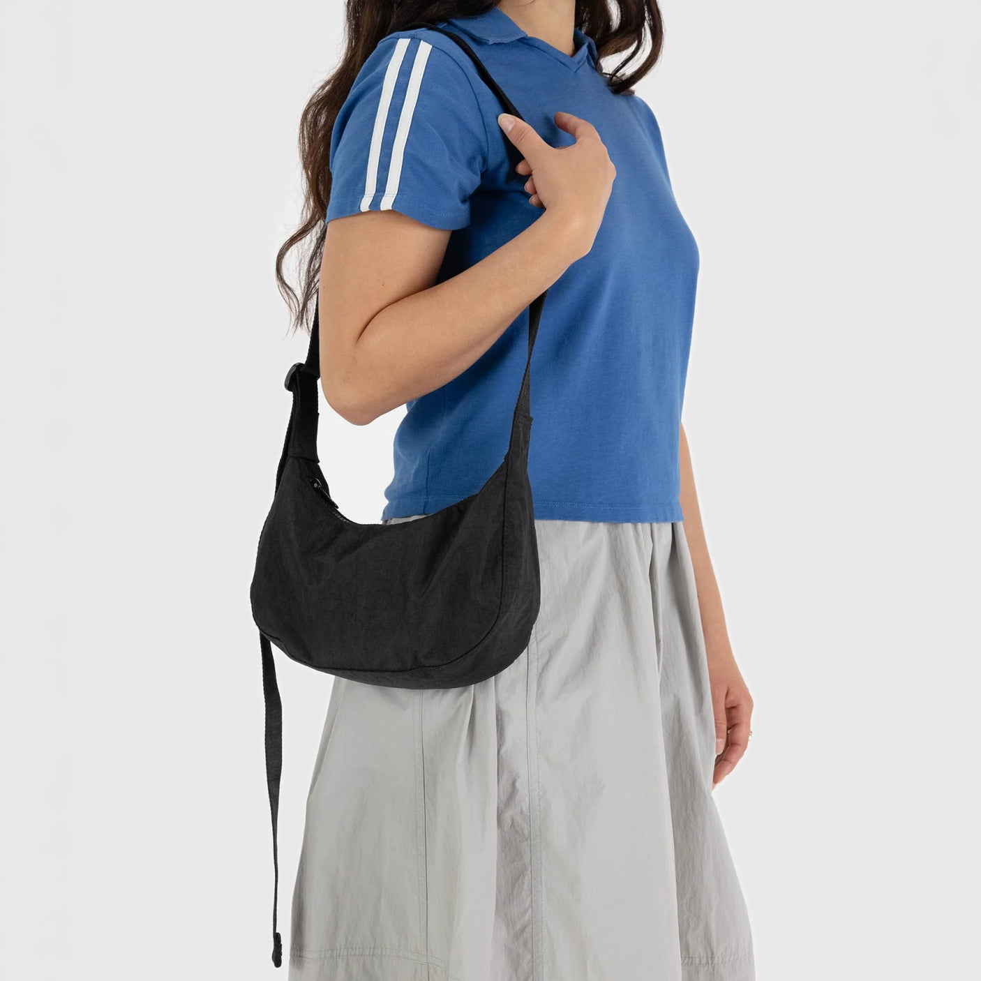 Black crescent shoulder bag with long strap and curved pocket opening