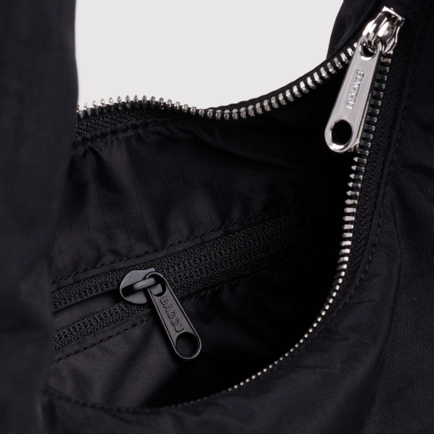 Black nylon small bag detail with silver zipper and interior pocket