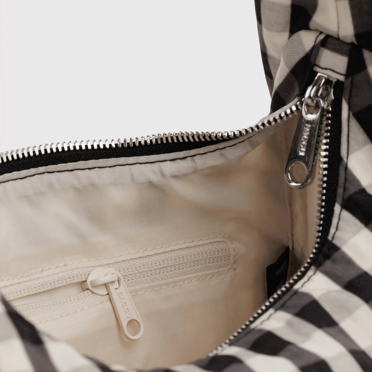 Open gingham nylon bag interior with beige lining and silver zipper pull