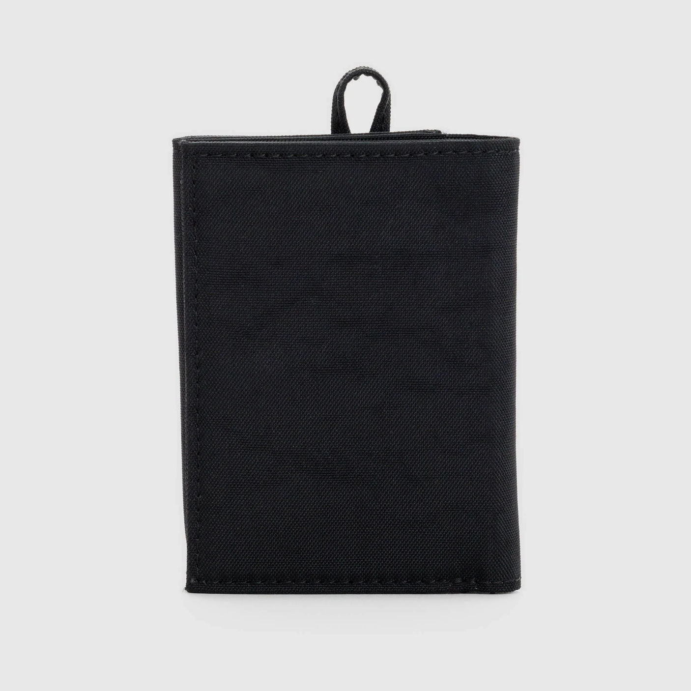 The Baggu Snap Wallet - Black from Baggu is a minimalist closed black fabric design with a small loop handle on top. It stands upright against a plain gray background, merging style and functionality seamlessly.