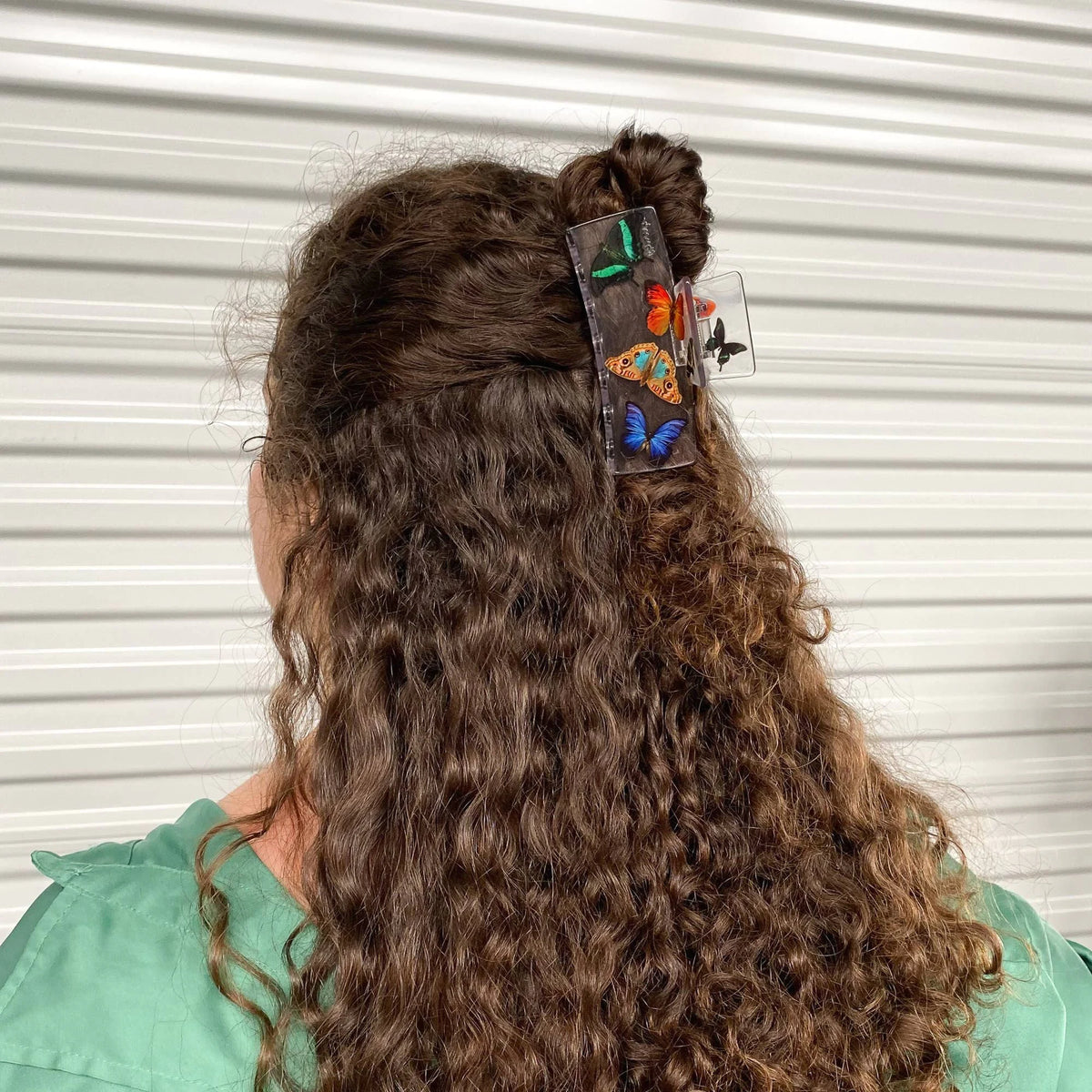 Butterfly box claw clip clipped to dark curly hair