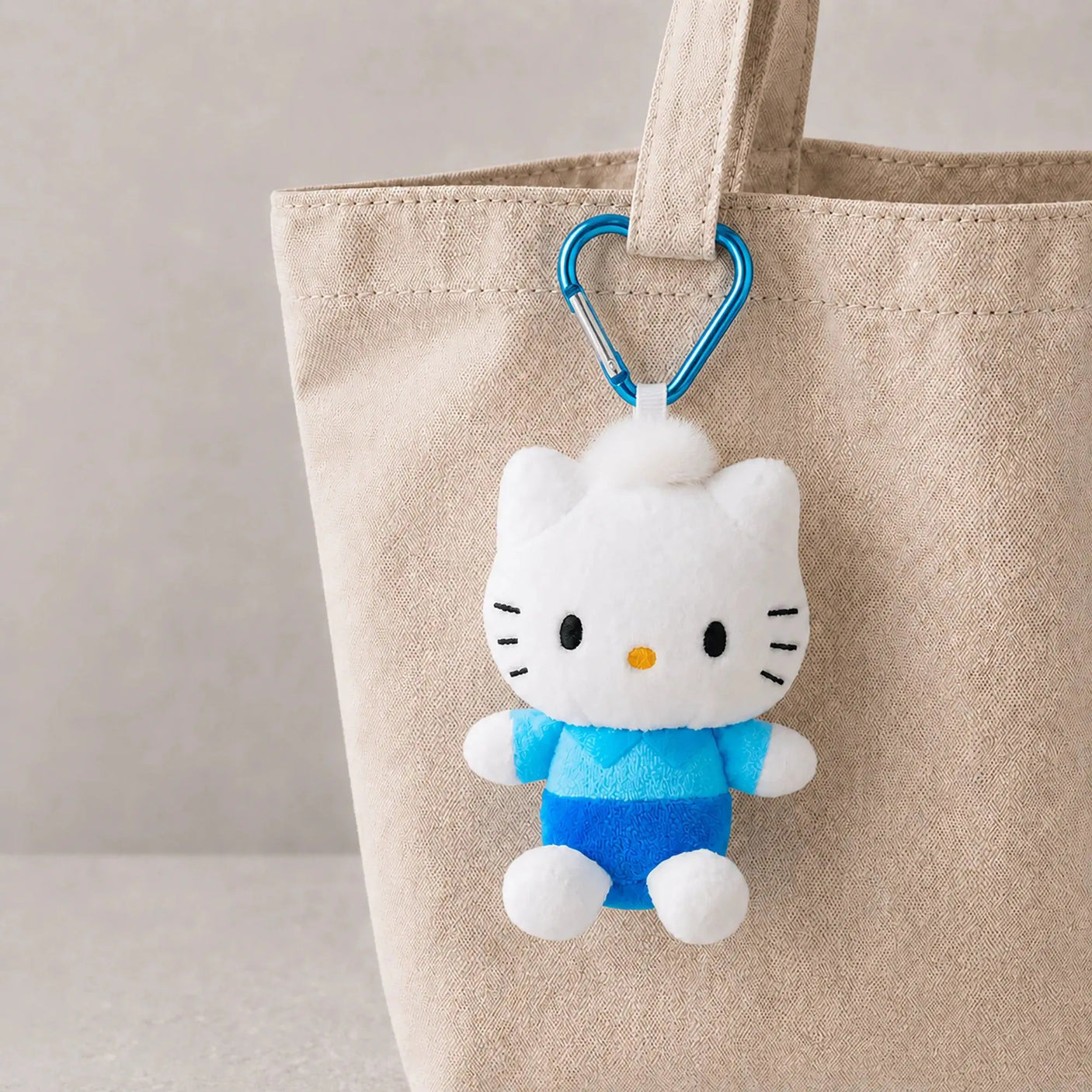 Heart clasp keychain with white plush cat in blue outfit and metal heart clip