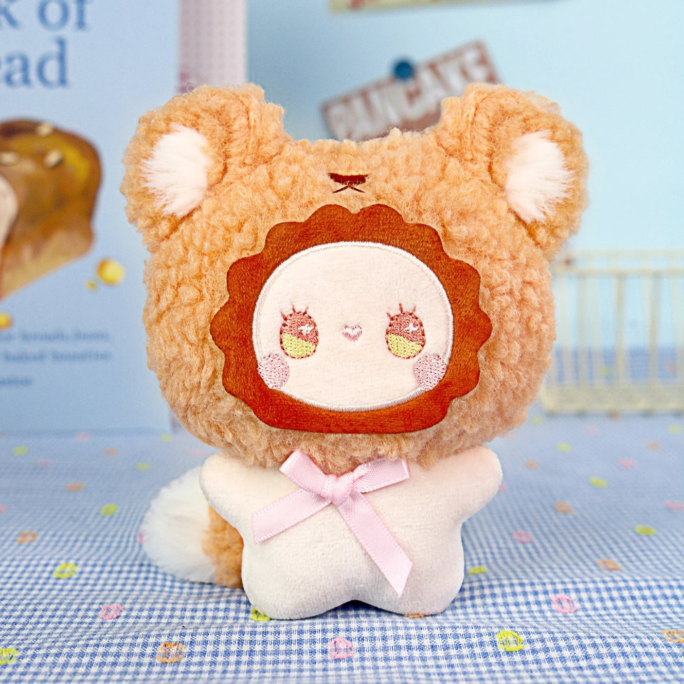The Emma Fuzzy Family Keychain Blind Box by Lucky Emma features a plush toy with a lion-like face, round ears, and a pink ribbonβperfect as a cute keychain or bag charm.