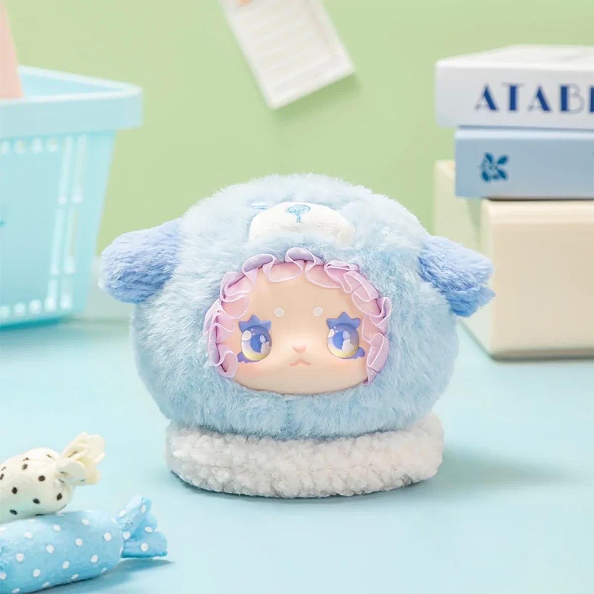 Blue plush Lovely Emma Rua Rua Zoo bag charm in sheep costume with ruffled hood on pastel blue background
