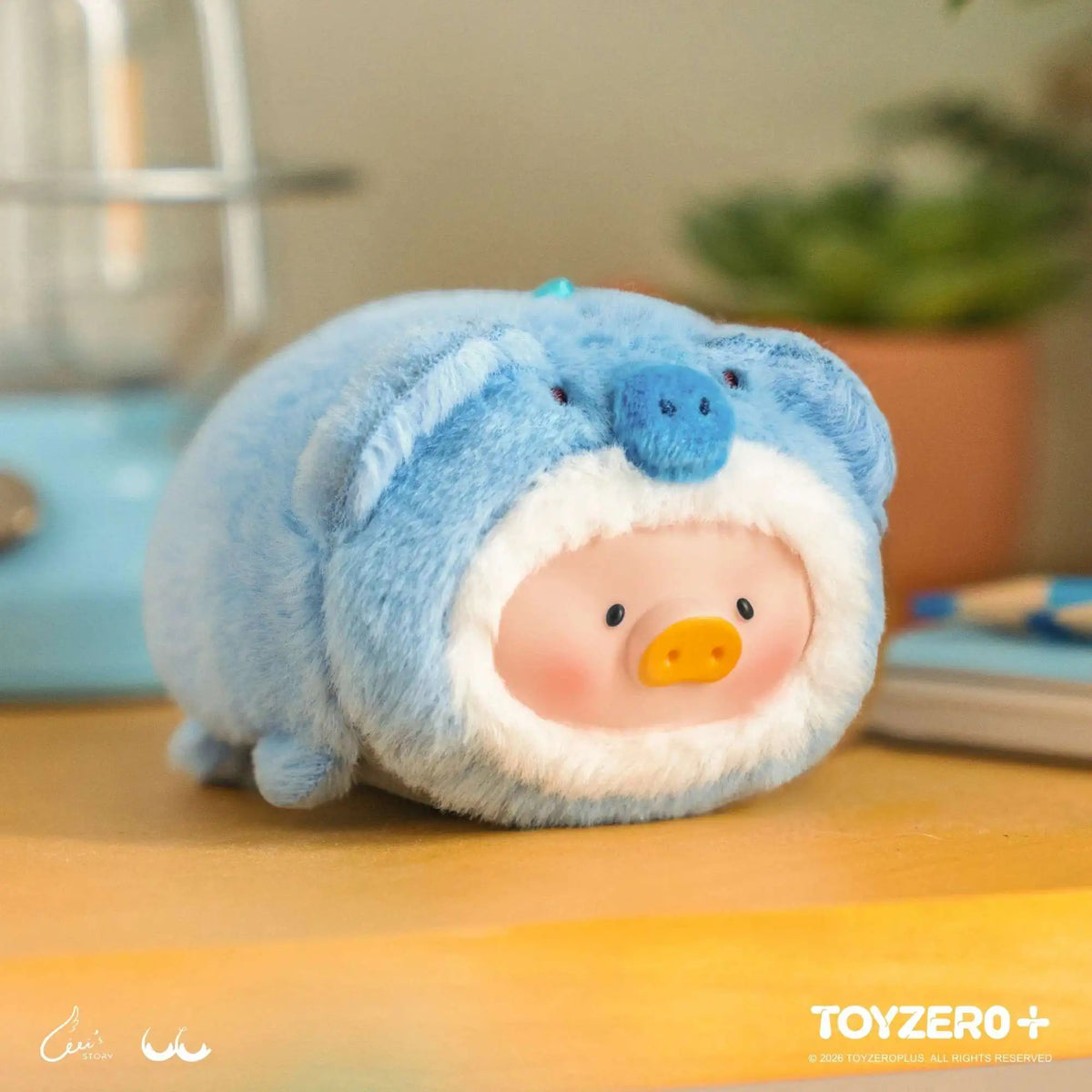 Blue dolphin-shaped plush keychain with hooded head and orange snout face