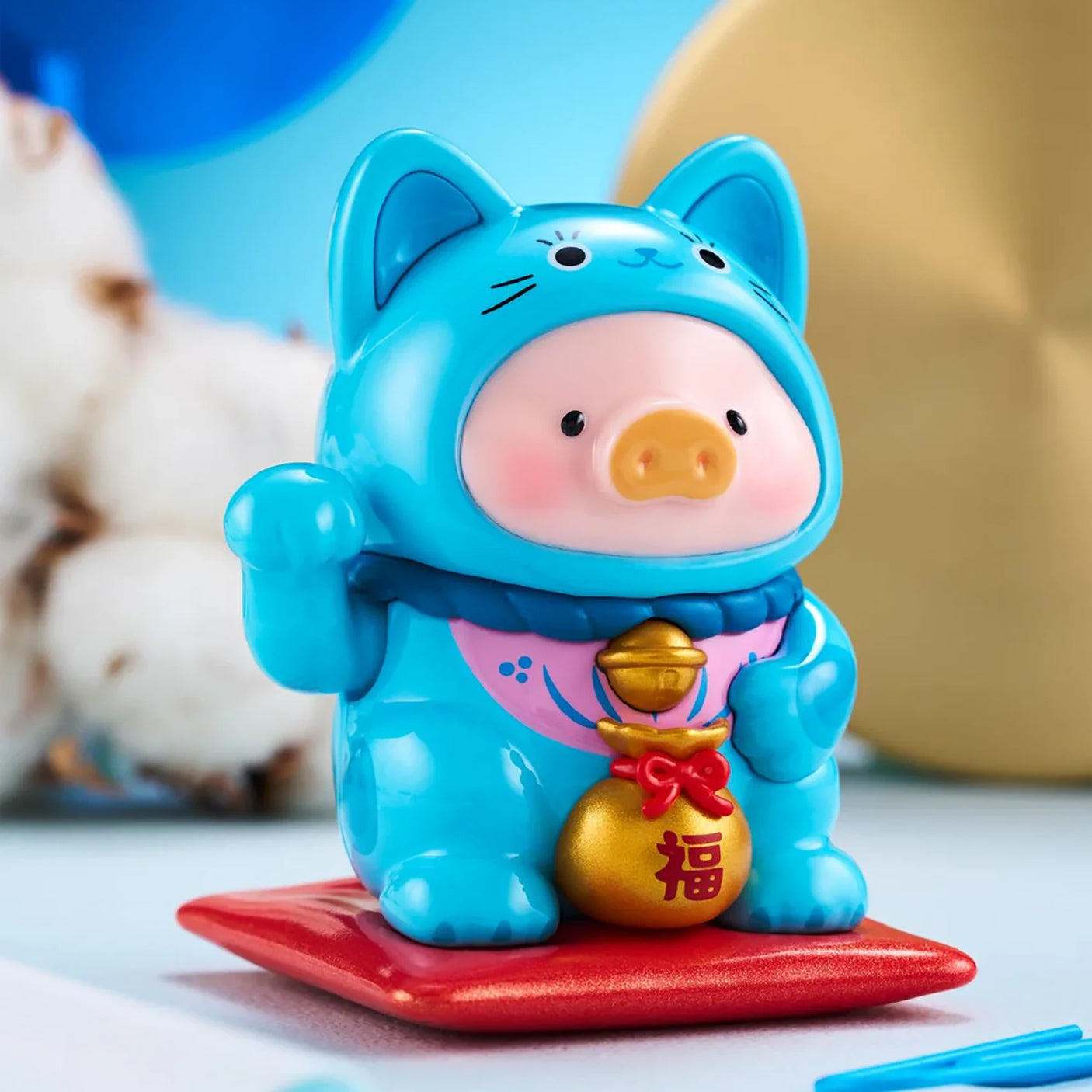 LuLu The Piggy - Lucky Cat Blind Box showing a piggy figure in a bright blue cat costume holding a gold charm by LuLu The Piggy