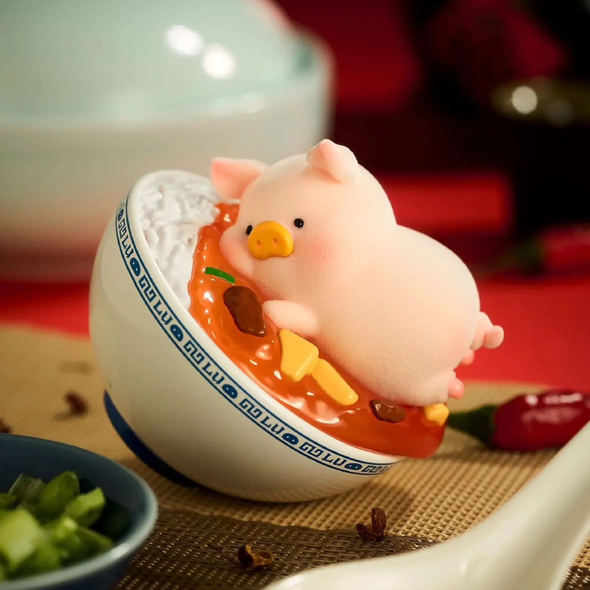 Pig chef figurine pouring from a ladle into a white bowl with orange sauce