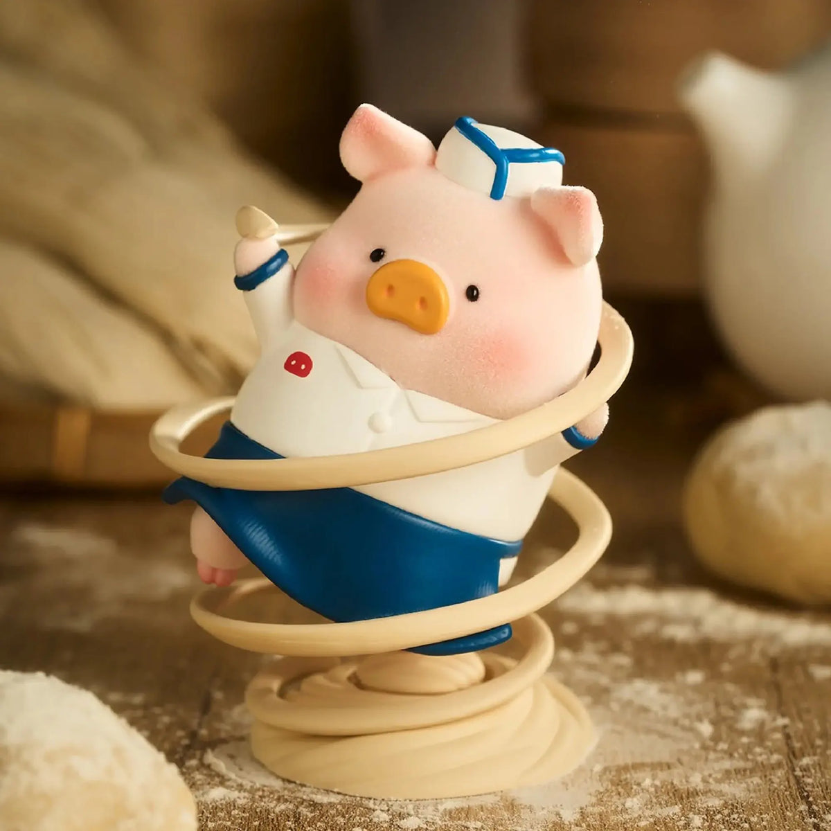 Pig chef toy figurine in blue apron on a spiral base
