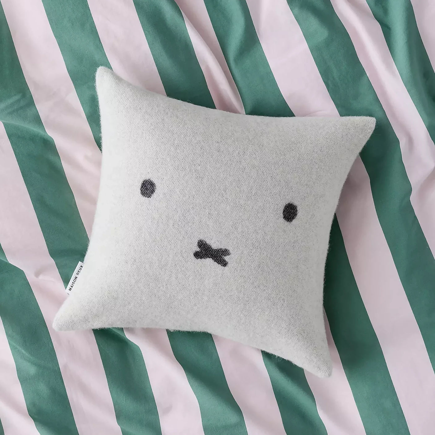 Light gray wool cushion cover with black Miffy-style face on a square pillow