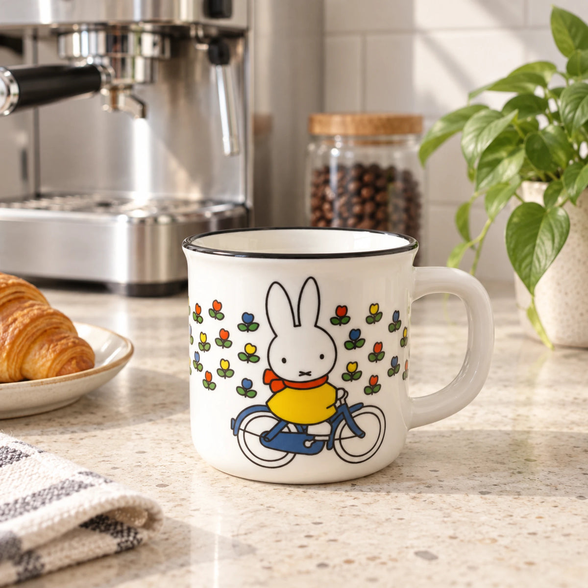 White ceramic mug with Miffy rabbit riding a bicycle, flower print on front