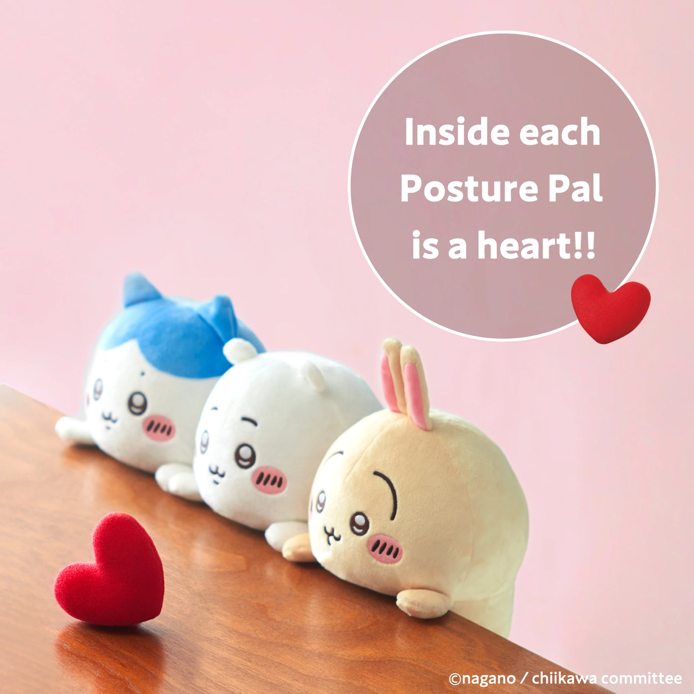 Three Chiikawa Posture Plush Buddy toys from the Chiikawa brand sit on a wooden surface gazing at a red heart. The image says, "Inside each Posture Pal is a heart!!"—a cute and gentle desk companion for posture support.