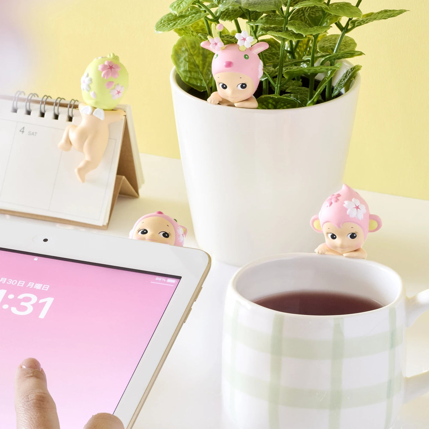 Cherry blossom Hippers mini figures peeking near a cup and potted plant