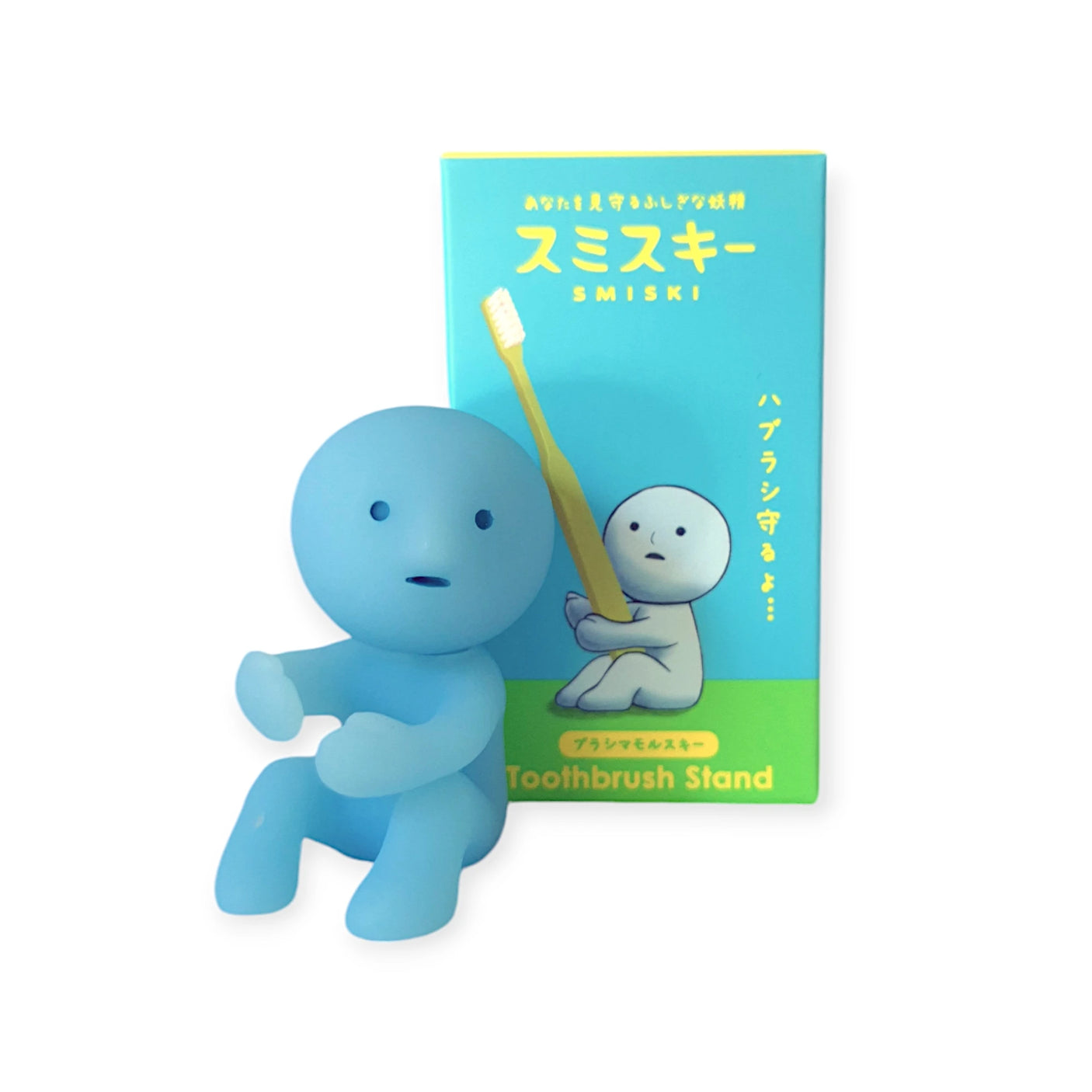 Beside its packaging, which displays an illustration of the figure holding a toothbrush, is a Smiski Toothbrush Holder - Protecting Figure in small blue. This glow-in-the-dark item combines charm and practicality for your bathroom.