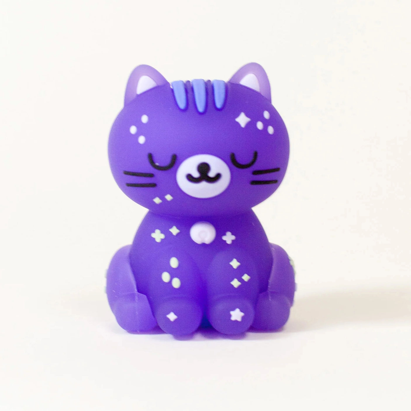 A small, purple Smoko Astrocats Blind Box figure with closed eyes and star and diamond details sits upright against a white background, adding cosmic charm to any collection.