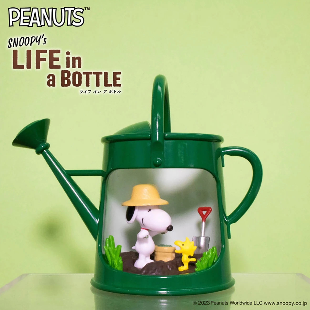 Green watering can diorama with Snoopy in farmer hat and Woodstock holding tiny shovel in garden scene