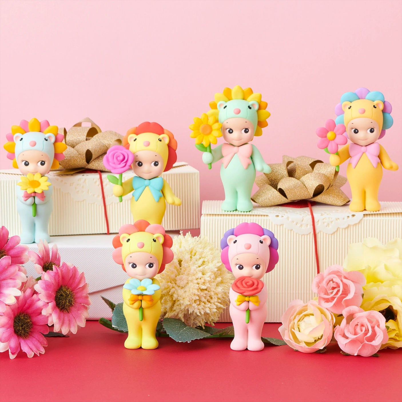 Mini flower gift figures standing on gift boxes with pink and yellow flower accessories