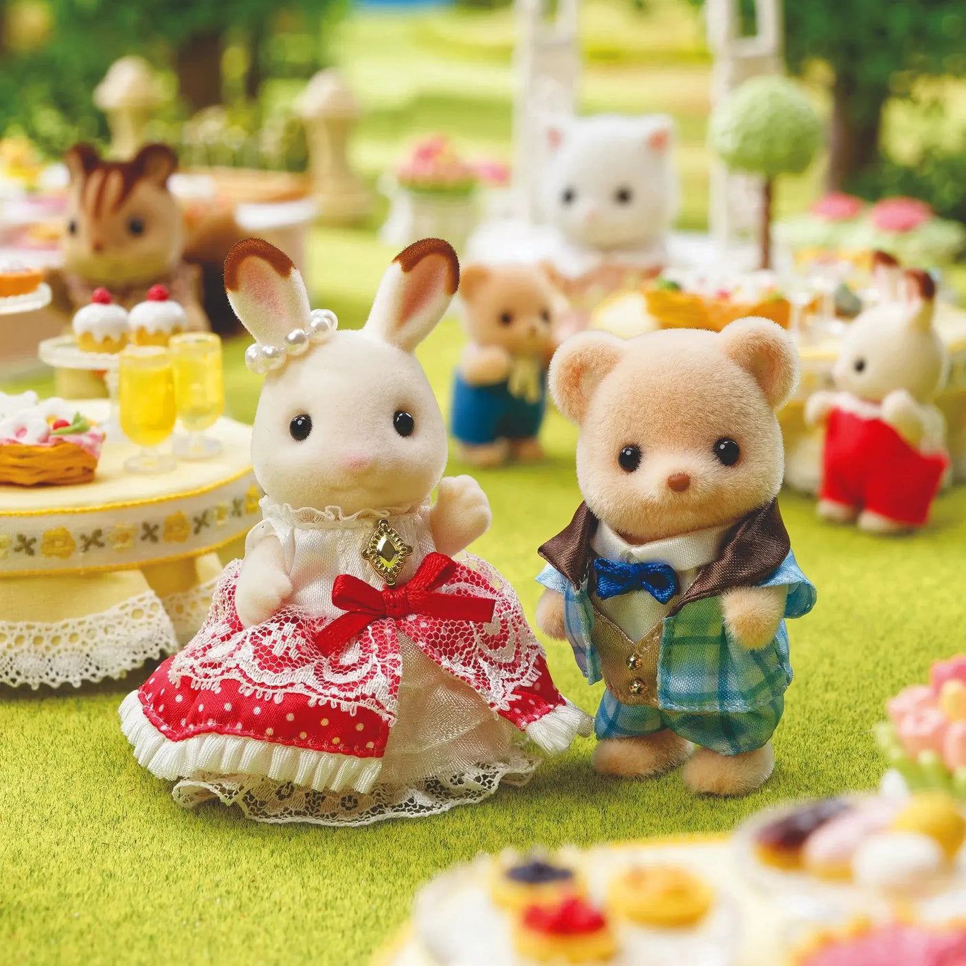Two plush doll figures outdoors: bunny in red frilly dress and bear in blue plaid vest
