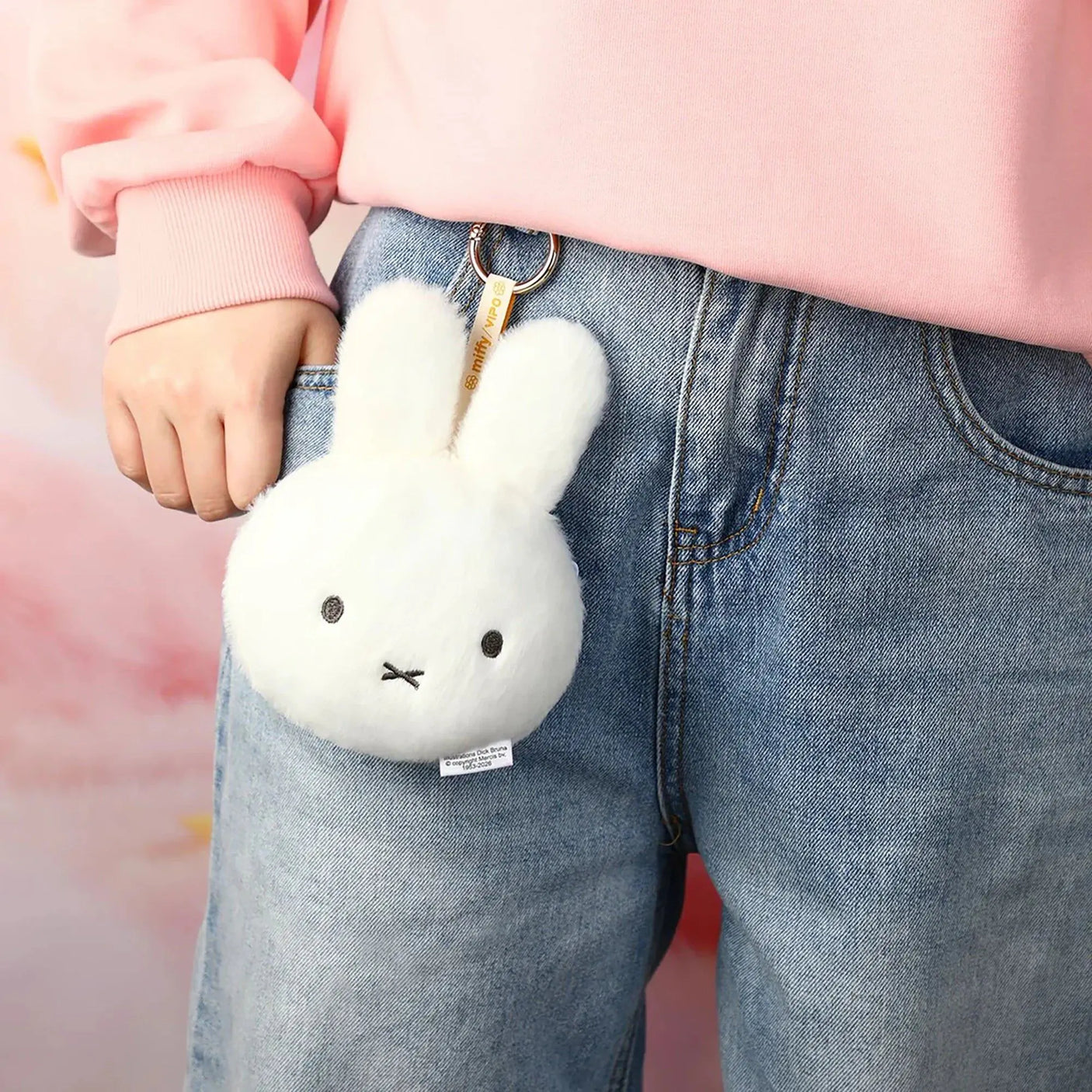 White plush bunny pouch keychain on blue jeans pocket with metal key ring