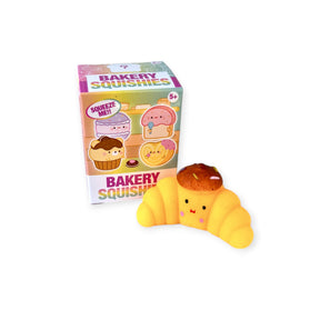 Explore the charming bakery-themed squishy toy in the shape of a cheerful croissant, encased in vibrant "Bakery Squishies Mini Blind Box" packaging from Yell. Ideal for stress relief, this cute item is a part of our Mini Blind Box collection.