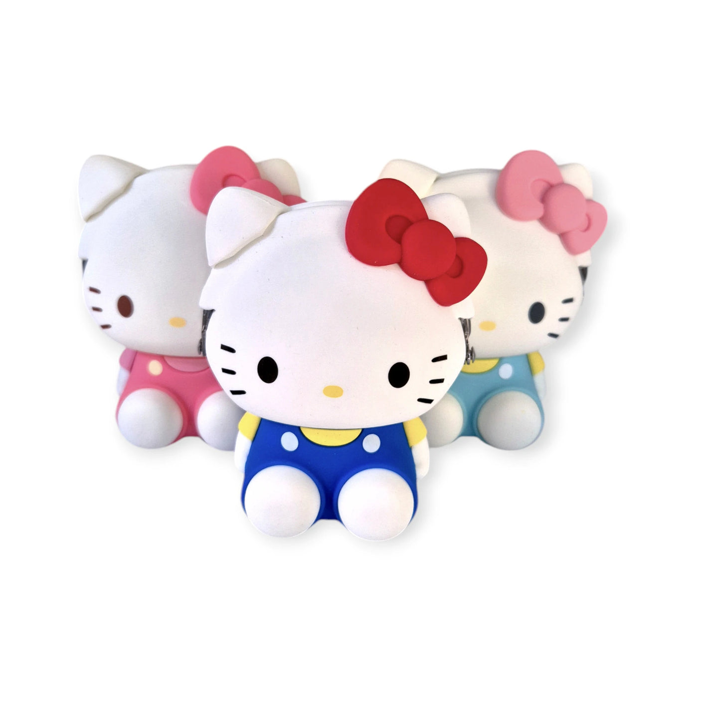 Three Hello Kitty figurines in vibrant blue, coral pink, and yellow outfits, with matching bows, are arranged in a triangular formation on a white background. The central figurine features the 3D Hello Kitty Case - Coral Pink by Hello Kitty.