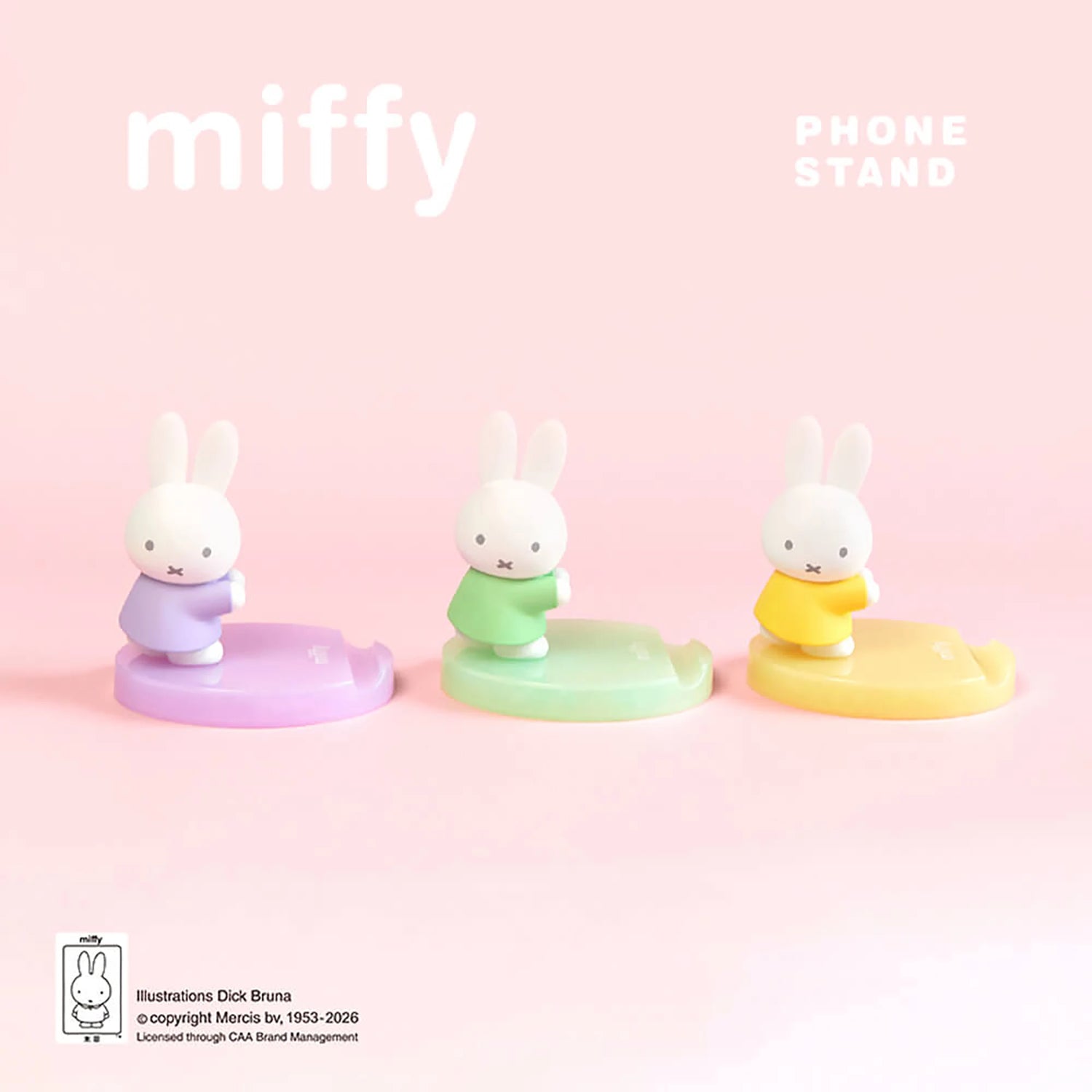 Three pastel bunny phone stands with white figurines on lavender, green, and yellow bases