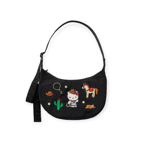 The Baggu Hello Kitty x Baggu Medium Nylon Crescent Bag - Western features cute western-themed graphics of Hello Kitty as a cowboy, a horse, cactus, stars, lasso, and a small orange animal.