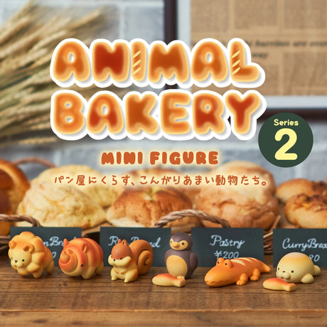 A row of animal-shaped mini figures from the "Animal Bakery Blind Box - Vol 2" by Dreams Inc is displayed before assorted bread, with signs and a series label evoking safari-inspired treats.