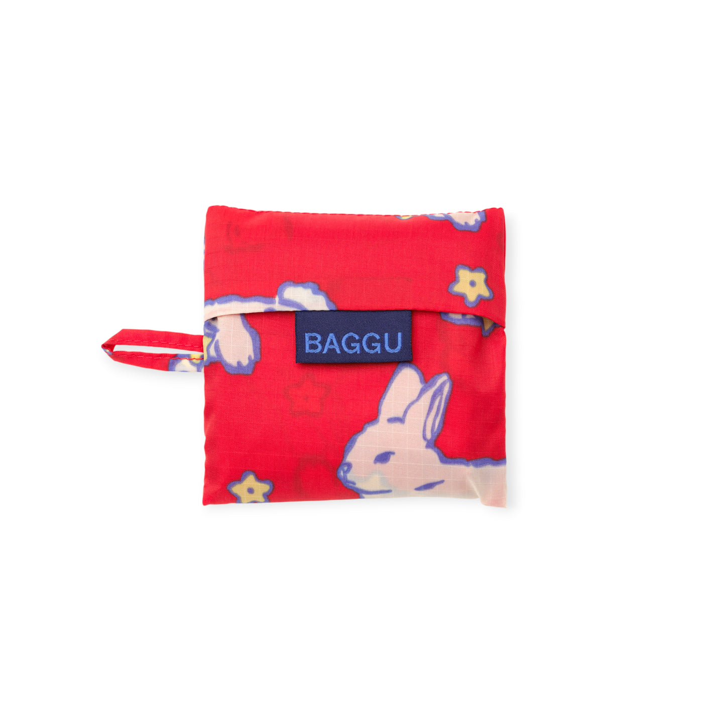 Red foldable fabric pouch with cream rabbit and small yellow flower pattern and navy blue label on white background