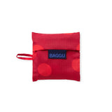 Baggu folded pouch bag in red polka dots with drawstring strap and logo patch