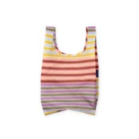 Folded reusable bag featuring pastel horizontal stripes in yellow, pink, purple, and green with navy blue label on white background