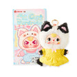Cat keychain plush with white fur, black ear tufts, and yellow dress; gold key ring