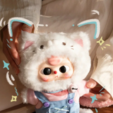 White plush kitten keychain with pink nose and blue-trim ears, held by hands