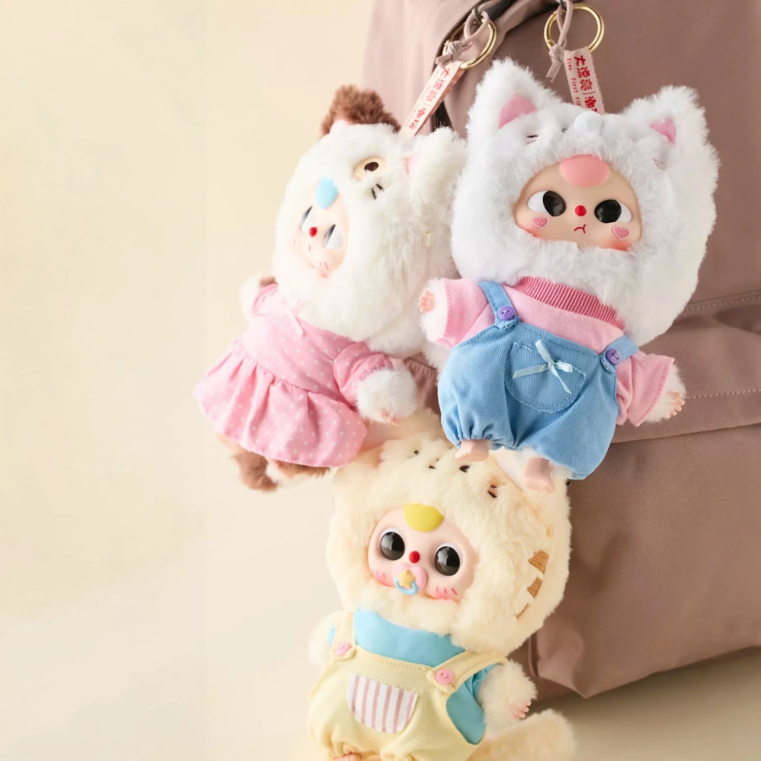 Set of three plush animal keychains with stitched faces and fabric outfits; metal key rings