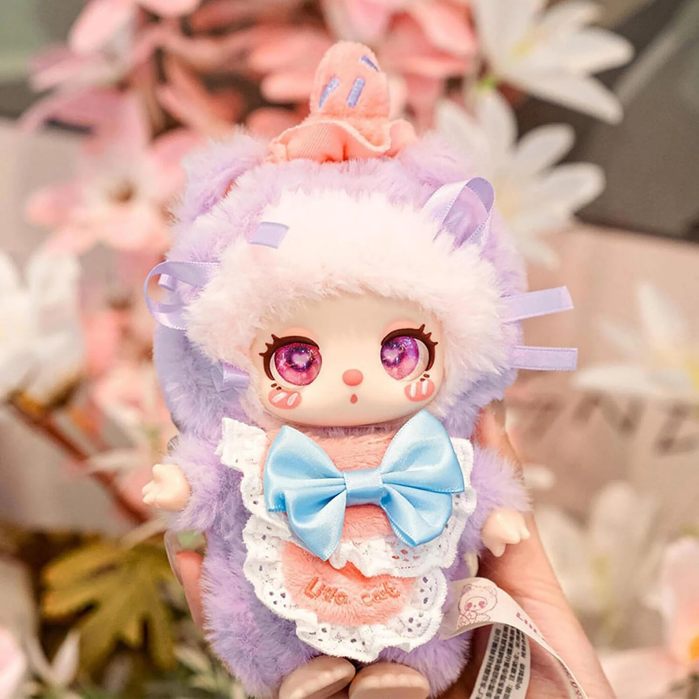Baby Three - Liila's Chef Kitten Blind Box plush doll in lavender fluffy onesie with large blue bow and pink cupcake hat accessory